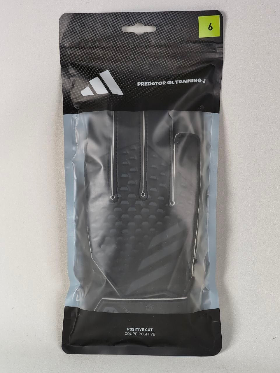 Packaged Adidas soccer cleats with clear front and black back on a white background