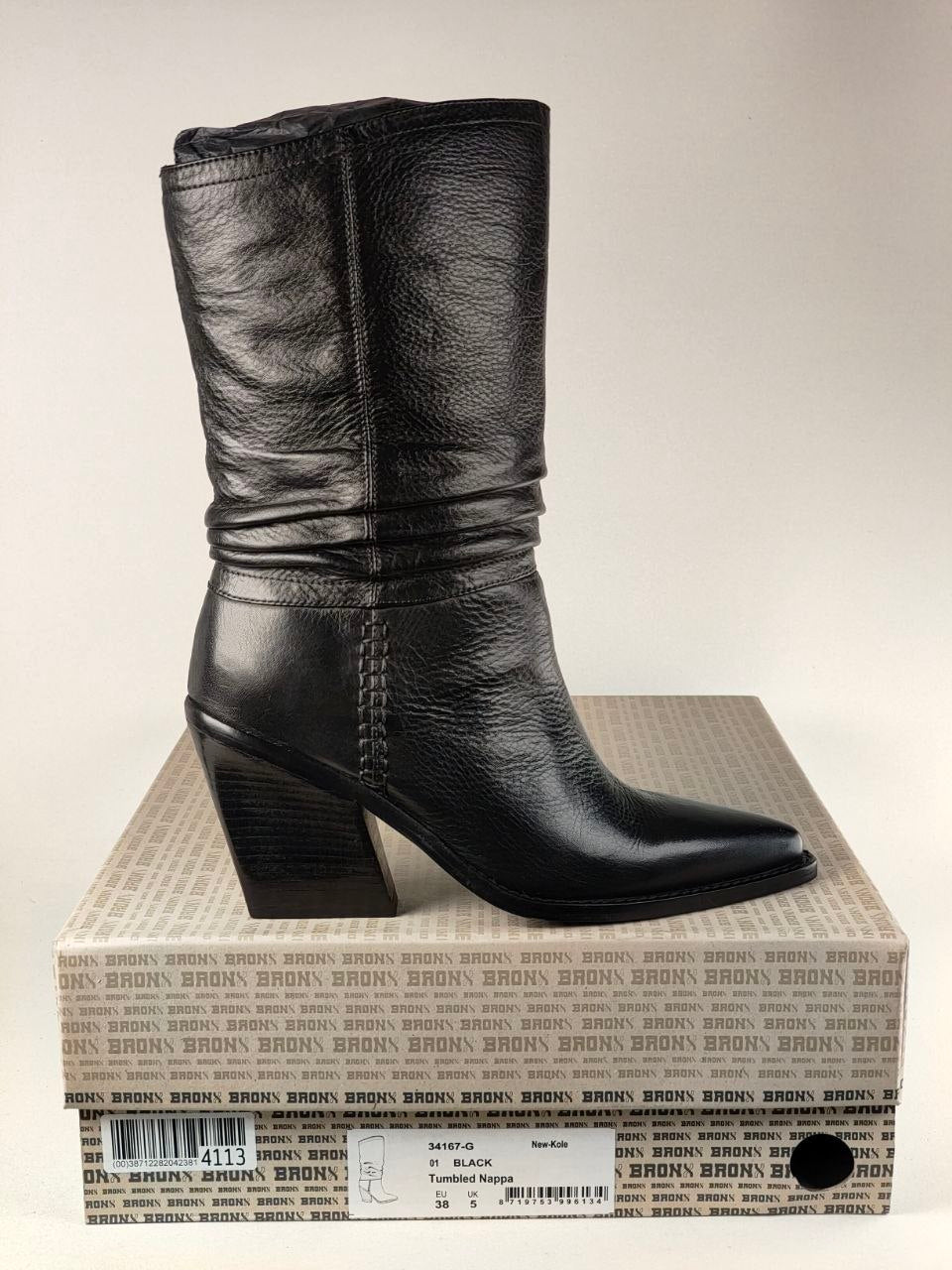 A black leather mid-calf boot with a low block heel, displayed on top of its branded shoebox against a neutral light background.