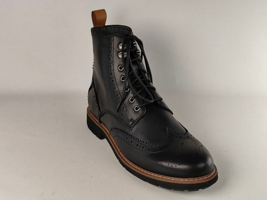 Black leather boot with brown sole on a light gray background