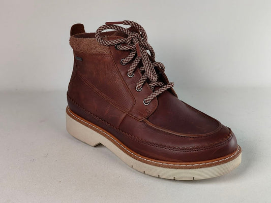 A dark brown leather lace-up ankle boot with a thick cream-colored sole and brown-and-white patterned laces, shown from a three-quarters angle against a neutral light gray background.