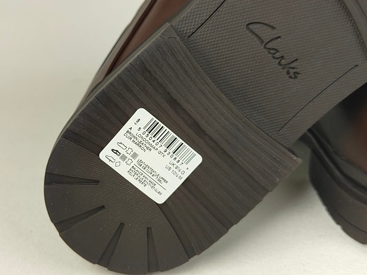 Close-up of a shoe sole with a label and 'Clarks' branding on a light background