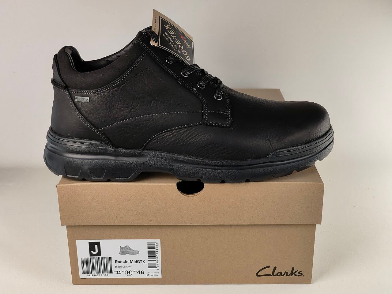 Black Clarks shoe on a cardboard box with a beige background