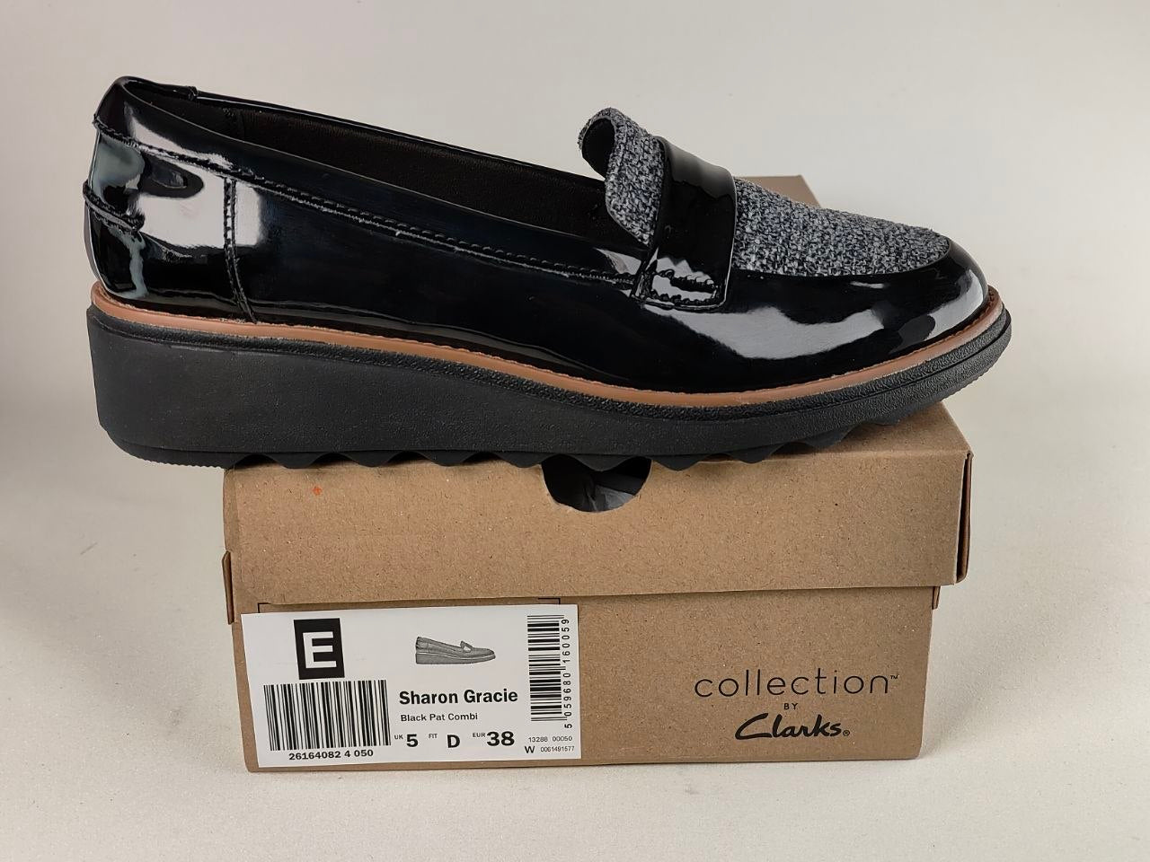 Black patent leather loafer on a Clarks shoe box with a white background