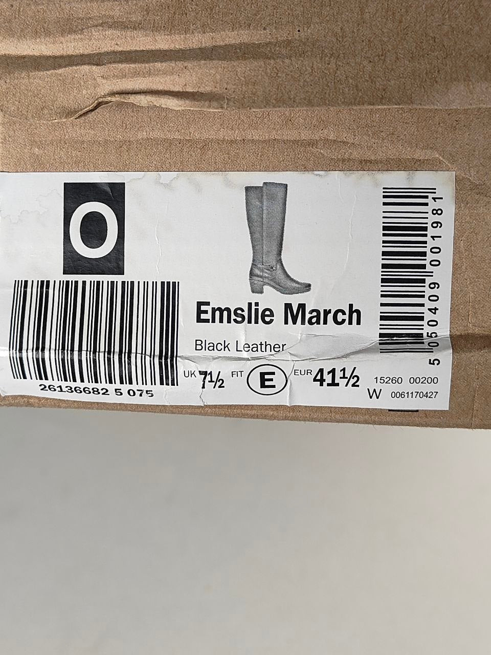 A close-up of a shoebox label for Emslie March black leather boots, showing a barcode, size information, and a simple illustration of tall boots.