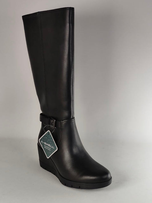 A single black leather knee-high boot with a wedge heel and a decorative strap detail near the ankle, shown against a neutral gray background. A brand tag is attached to the strap.