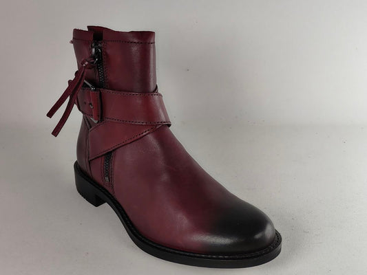 A single dark burgundy leather ankle boot with a side zipper, decorative strap with a buckle, and a matching hanging tie detail, shown against a plain light gray background.