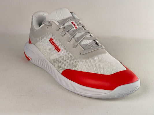 A Kempa athletic sneaker in white and light gray with a bold red toe cap and red branding on the side, photographed on a neutral light gray background.