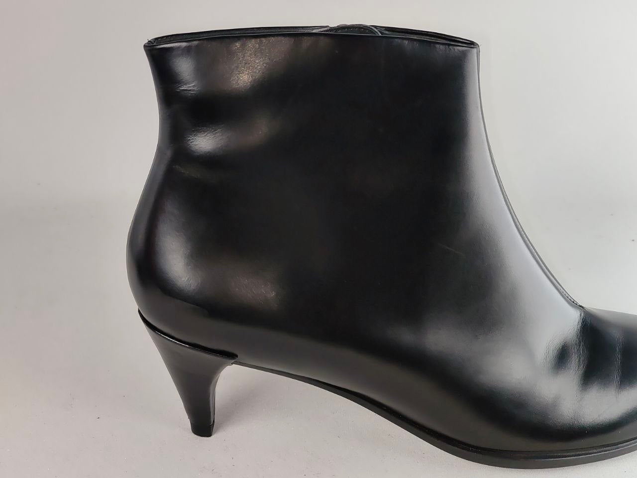 A single black leather ankle boot with a kitten heel, shown from a side profile view against a light gray background.
