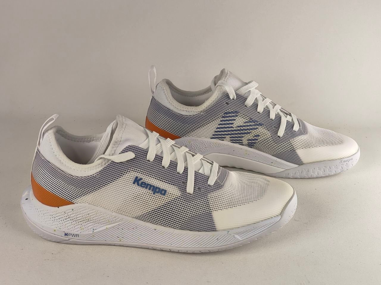 A pair of Kempo athletic sneakers in white, gray, and orange, displayed on a neutral light beige background.