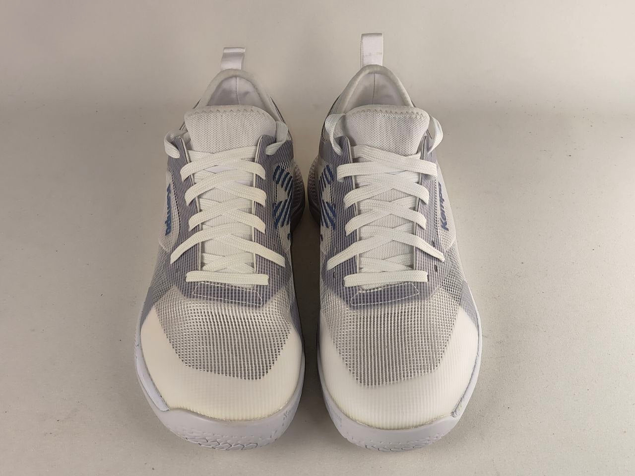 A pair of white and gray athletic sneakers with blue accents, shown from the front on a light gray background.