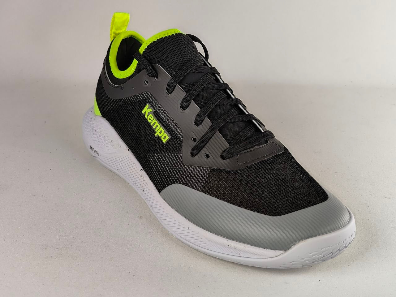 A black and gray athletic sneaker with neon yellow-green accents, featuring a white sole and the brand name 'Kemped' printed on the side, photographed on a light gray background.