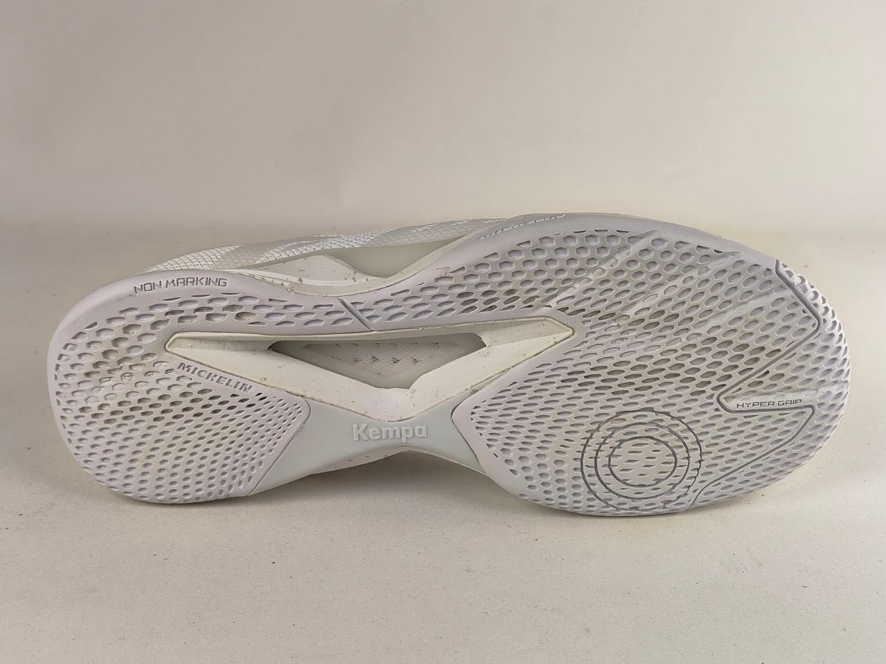 The outsole of a white athletic shoe, showing the textured tread pattern and branding including 'Kampo' and 'Mitchell & Ness'.