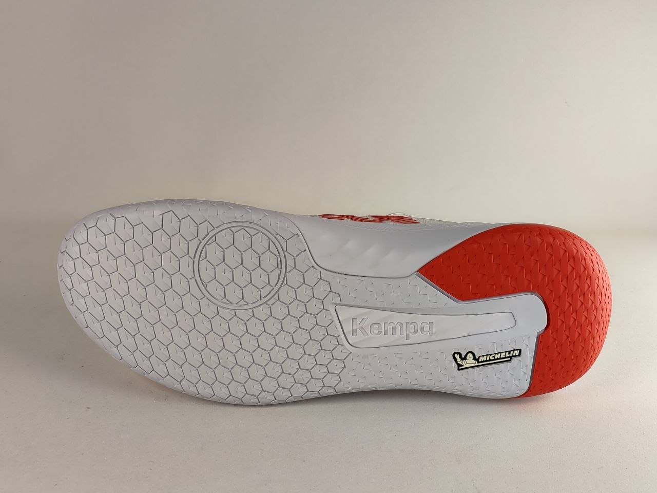 The outsole of a Kempa indoor soccer shoe, featuring a white honeycomb-patterned tread with a red heel counter and a visible Michelin logo.