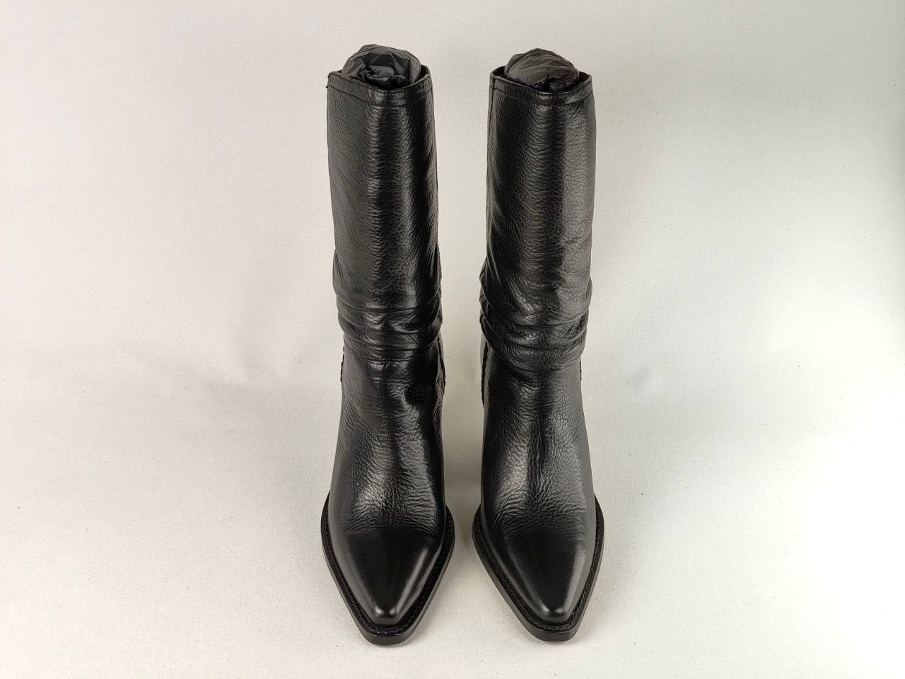 A pair of black leather mid-calf boots with pointed toes and a textured grain, photographed against a plain light background.