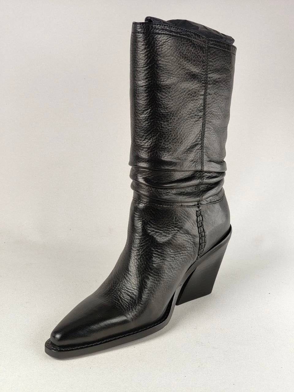 A single black leather mid-calf boot with a pointed toe and a low block heel, photographed against a neutral light gray background.