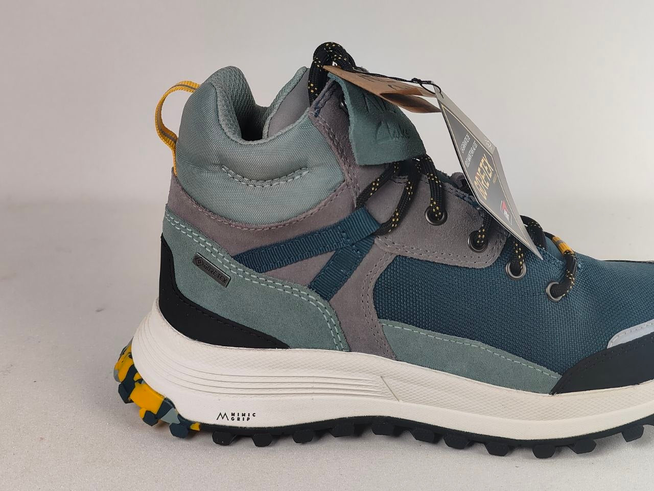 A mid-top hiking boot from MTSU, featuring a color-blocked design in slate blue, gray, and teal, with a white midsole and yellow accents on the pull loop and outsole.
