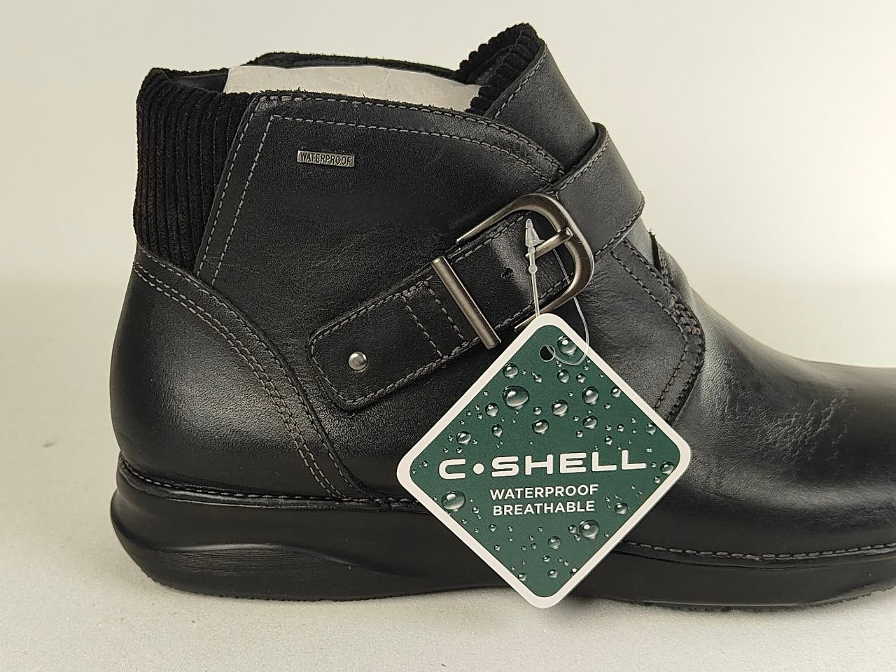 A black leather ankle boot with a hook-and-loop strap and buckle, featuring a hanging C-SHELL waterproof tag, shown against a light gray background.