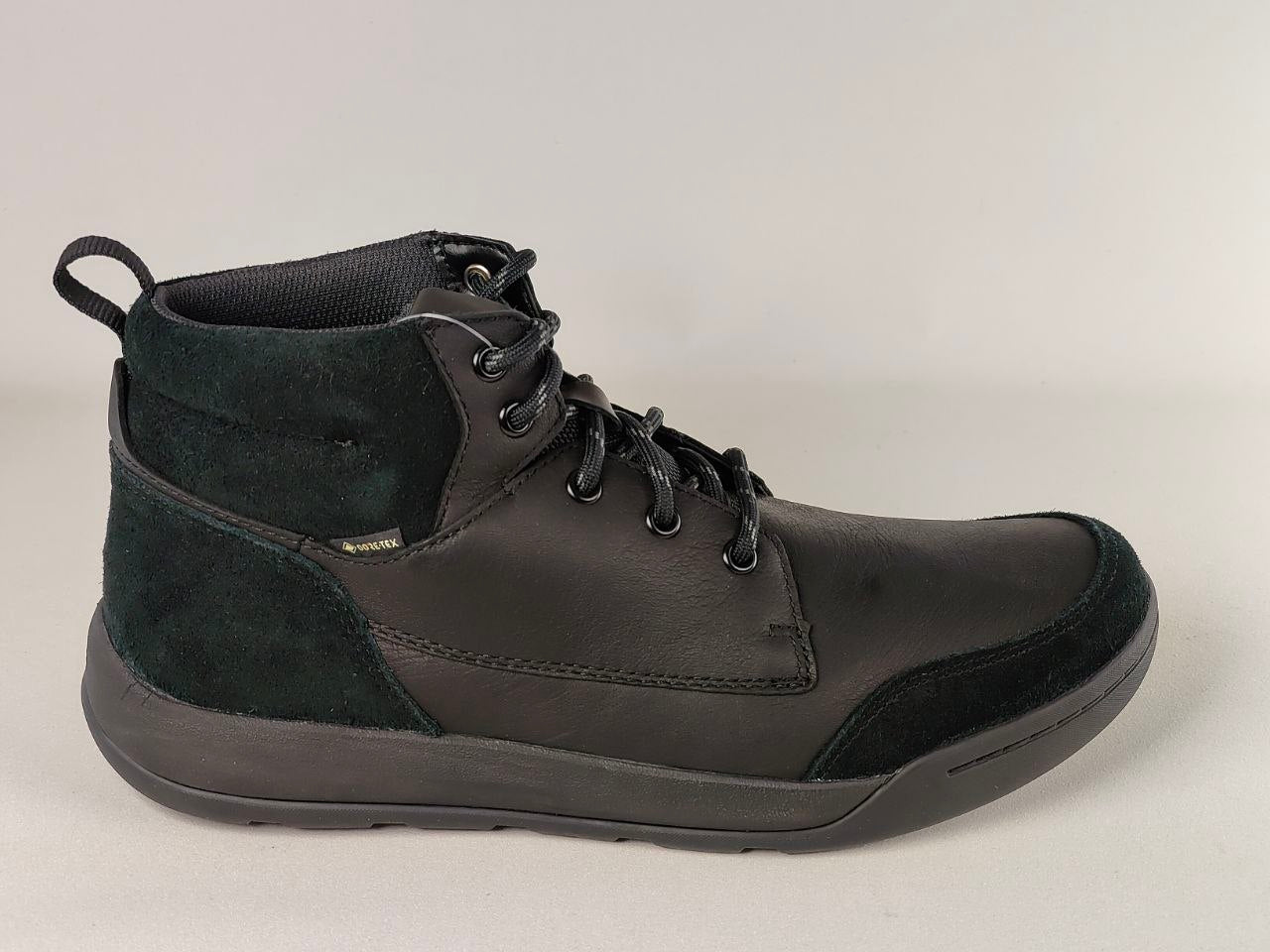 Black leather boot with a gray patch on a light gray background
