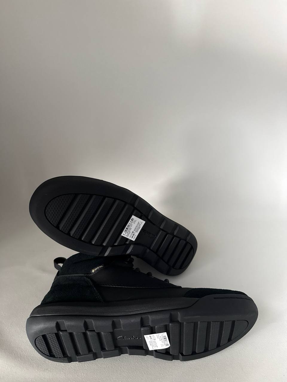 Pair of black boots on a light gray background