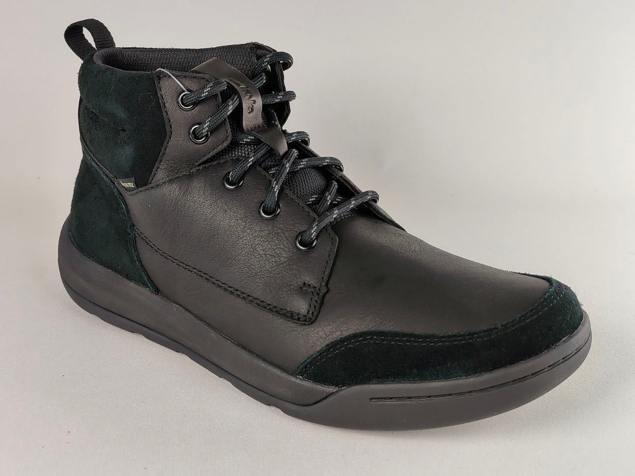 Black leather boot with lace-up design on a light gray background