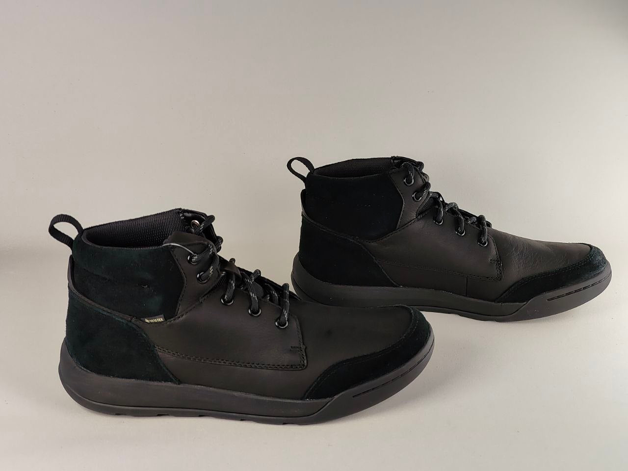 Pair of black high-top sneakers on a light gray background
