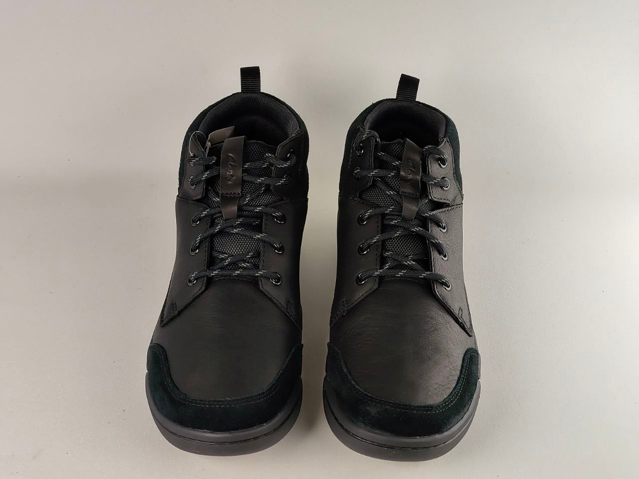 Pair of black leather shoes on a light gray background
