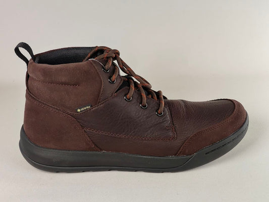 Brown leather boot with black sole on a light gray background