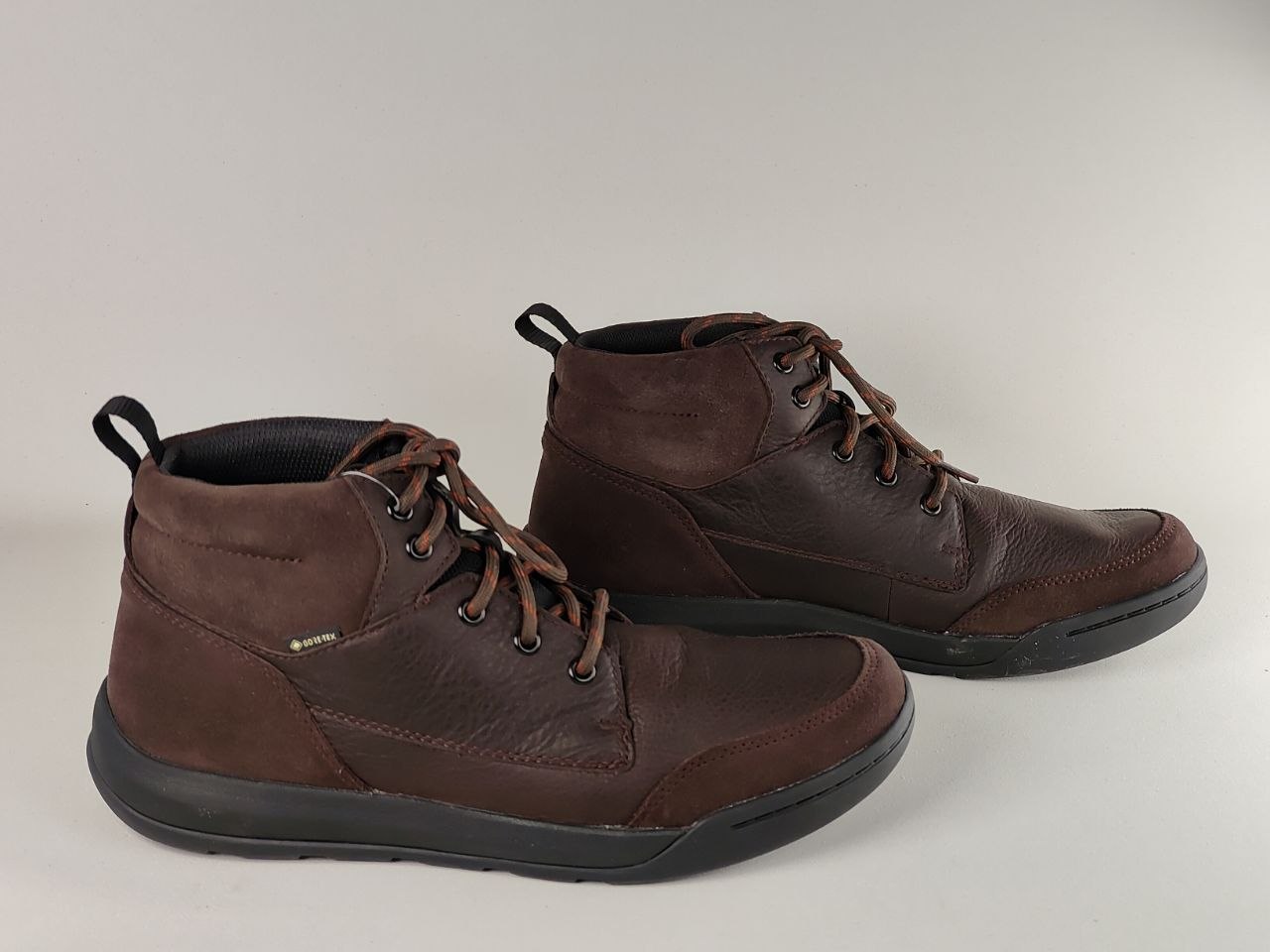 Pair of brown leather boots on a light gray background
