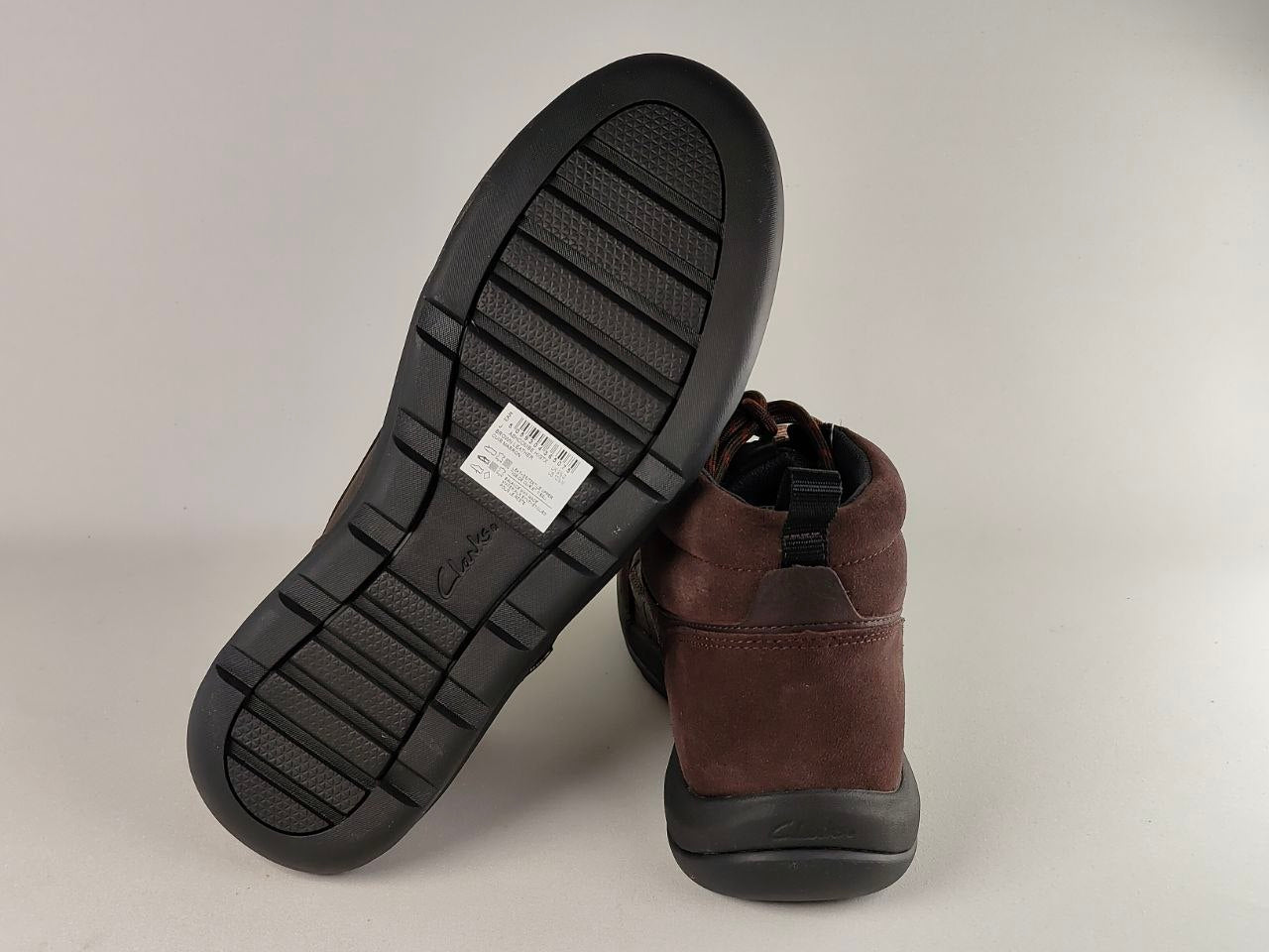 Brown ankle boot with black sole on a light gray background