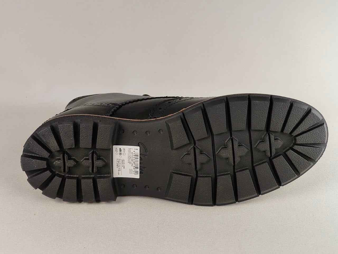Black boot sole with tread pattern on a light gray background