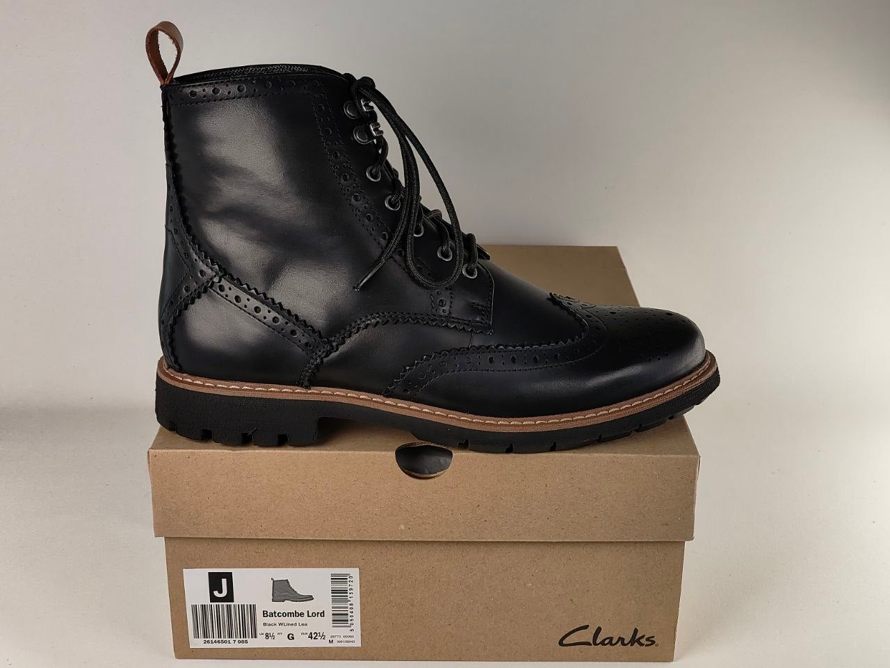 Black leather boot on a Clarks shoe box with a neutral background