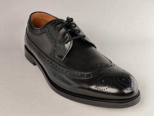 Black leather dress shoe on a light gray background