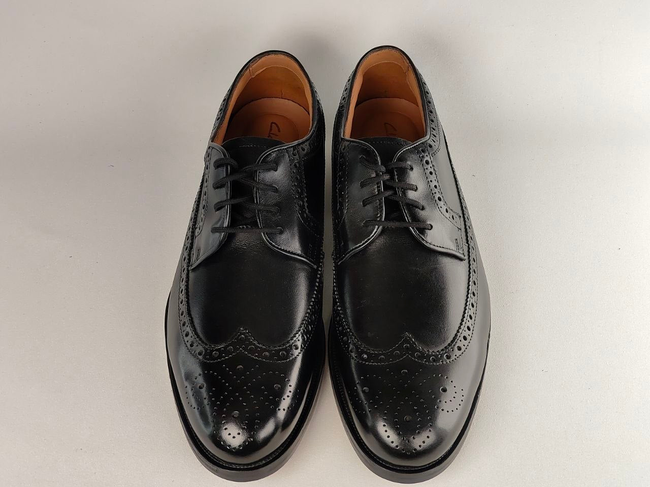 Pair of black leather dress shoes on a light gray background