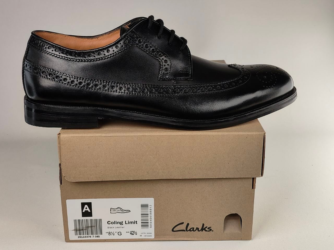 Black leather dress shoe on a Clarks branded box against a neutral background
