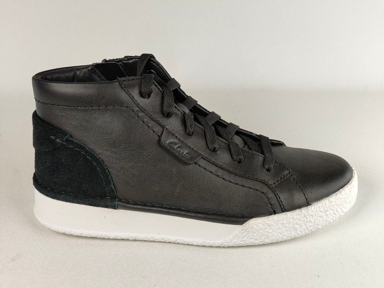 Black high-top sneaker with white sole on a light gray background