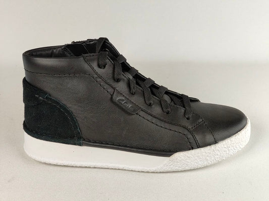 Black high-top sneaker with white sole on a light gray background
