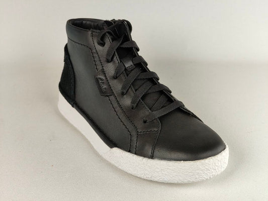 Black high-top sneaker with white sole on a light gray background