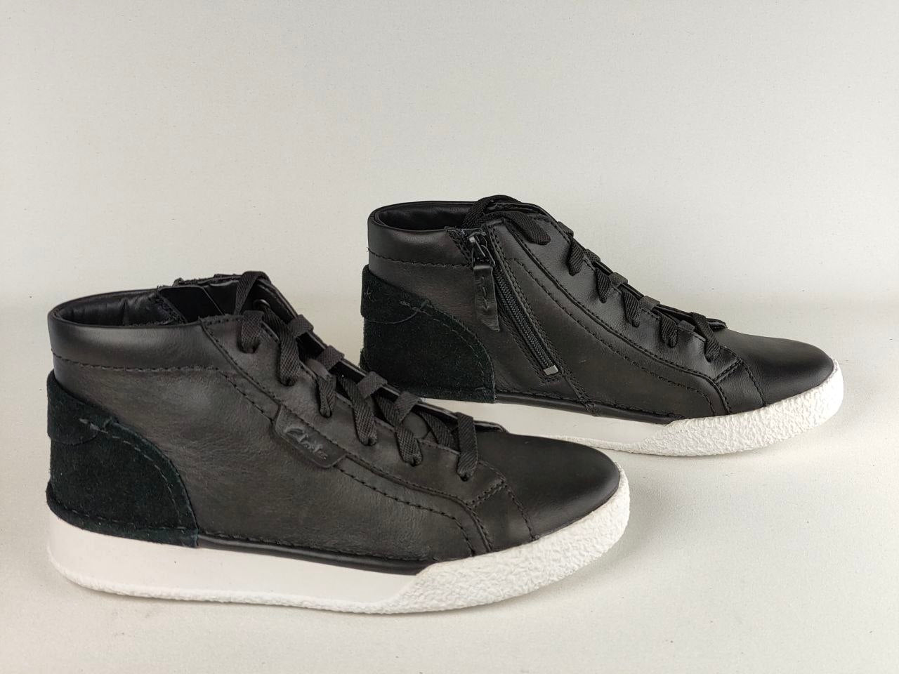 Pair of black high-top sneakers on a light gray background