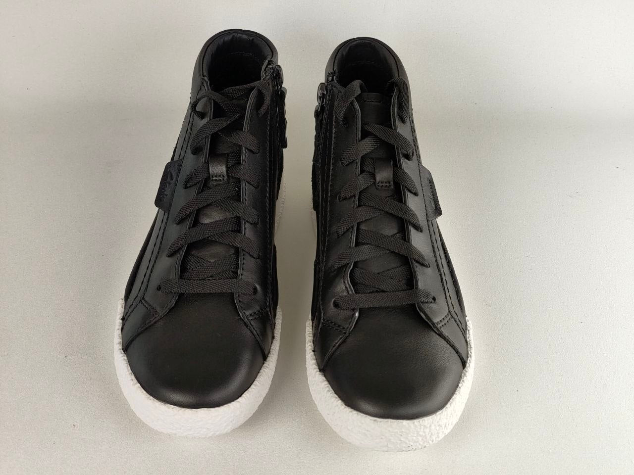 Pair of black high-top sneakers on a light gray background