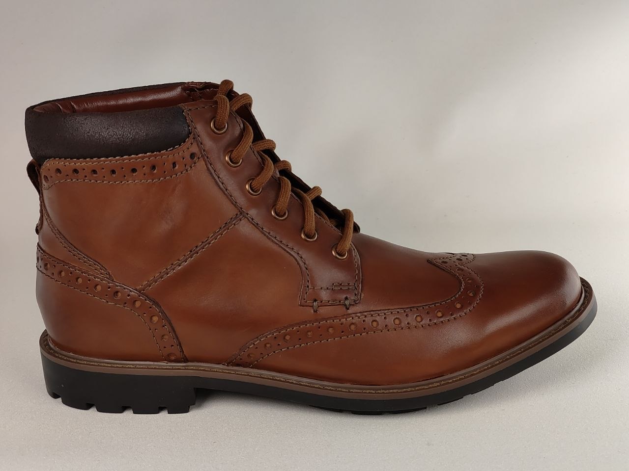 Brown leather brogue boot on a light gray background