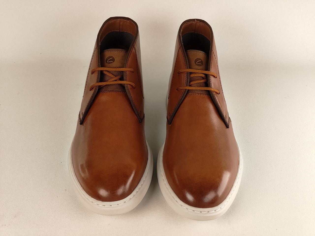 Pair of brown leather shoes on a light beige background