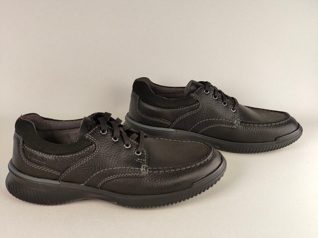 Pair of black leather shoes on a light gray background