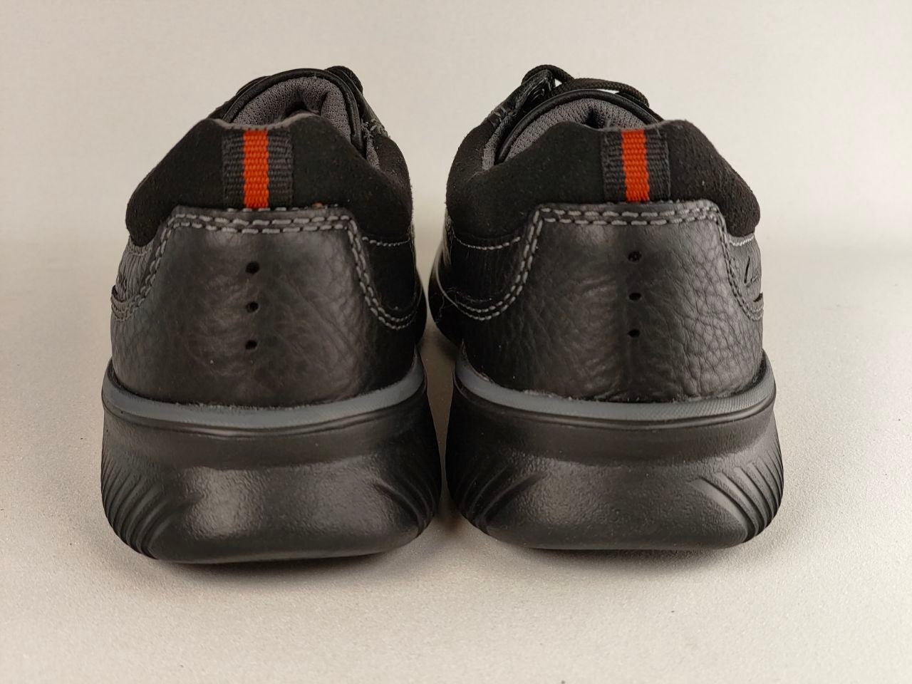 Black shoes with red accents on a light gray background