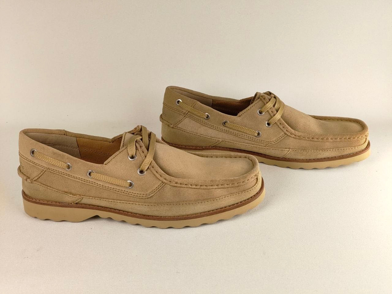 Pair of tan casual shoes on a light beige background