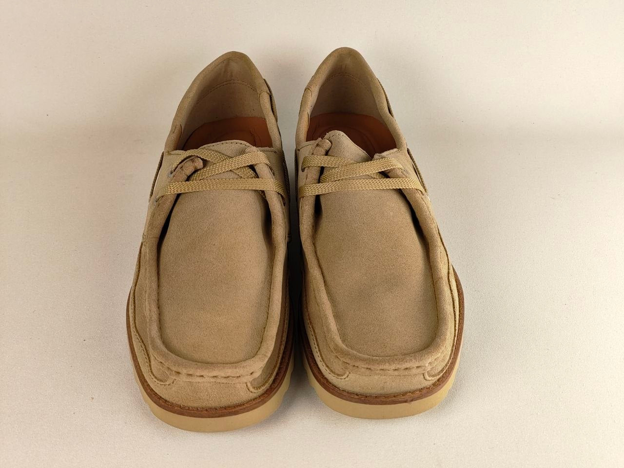 Pair of beige loafers on a light beige background