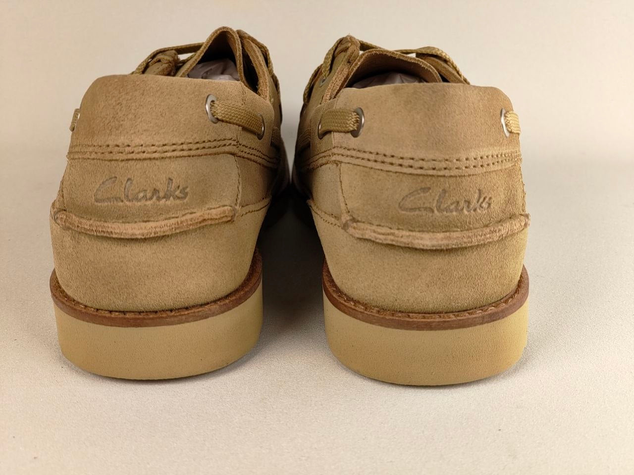 Pair of tan Clarks shoes on a light gray background