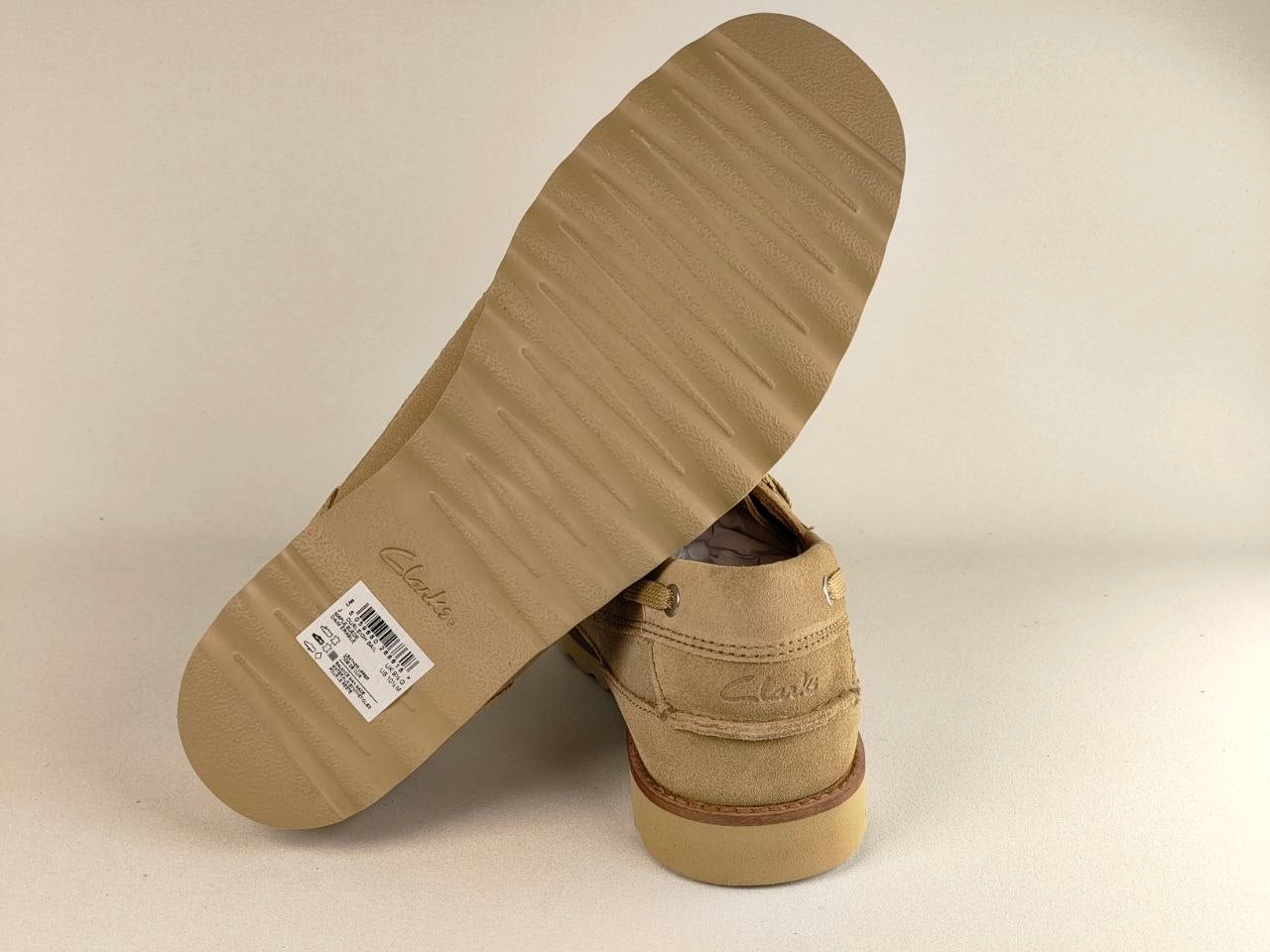Tan shoe with a visible brand label on a beige background
