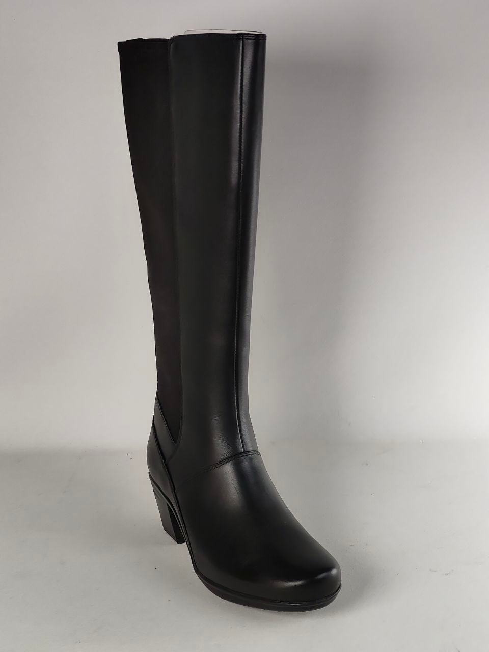 A single black leather knee-high boot with a block heel, shown from a three-quarter angle against a neutral gray studio background.