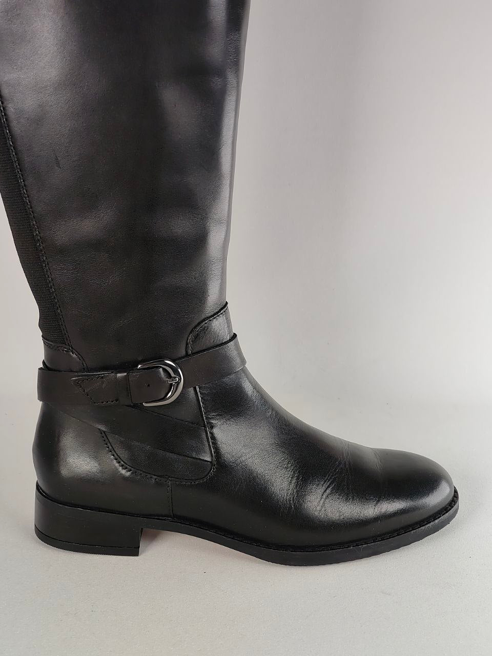 A black leather knee-high riding boot with a side buckle strap, shown in profile against a light gray background.