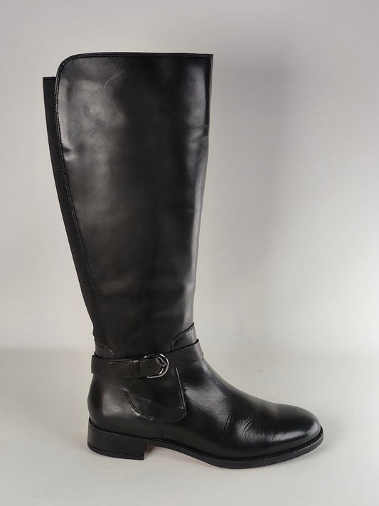 A single black leather knee-high boot with a side buckle strap, shown in profile against a neutral light gray background.